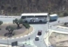 Un autobus con un remolque remolque, en plena rotonda, se detiene y da marcha atrás para quedarse aparcado en una vía de acceso a la misma. Los helicópteros captan la infracción y los vehículos que tiene que detenerse a esperar que éste termine la maniobra